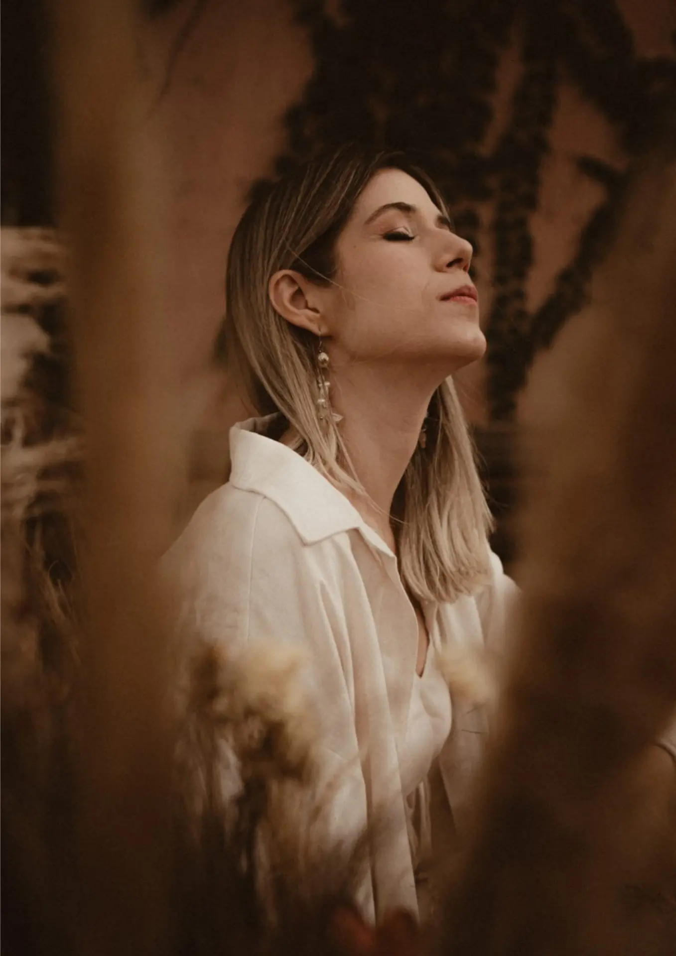 Retrato de Natália Alleoni sentada entre plantas